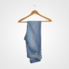 Pair of casual blue jeans hanging on a wooden hanger against a plain white background, showcasing everyday denim wear.