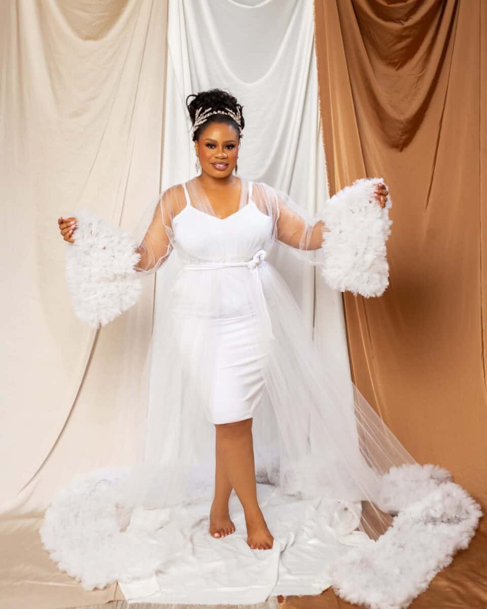 Bride wearing a luxury tell bridal robe with fringe on the hem and cuff